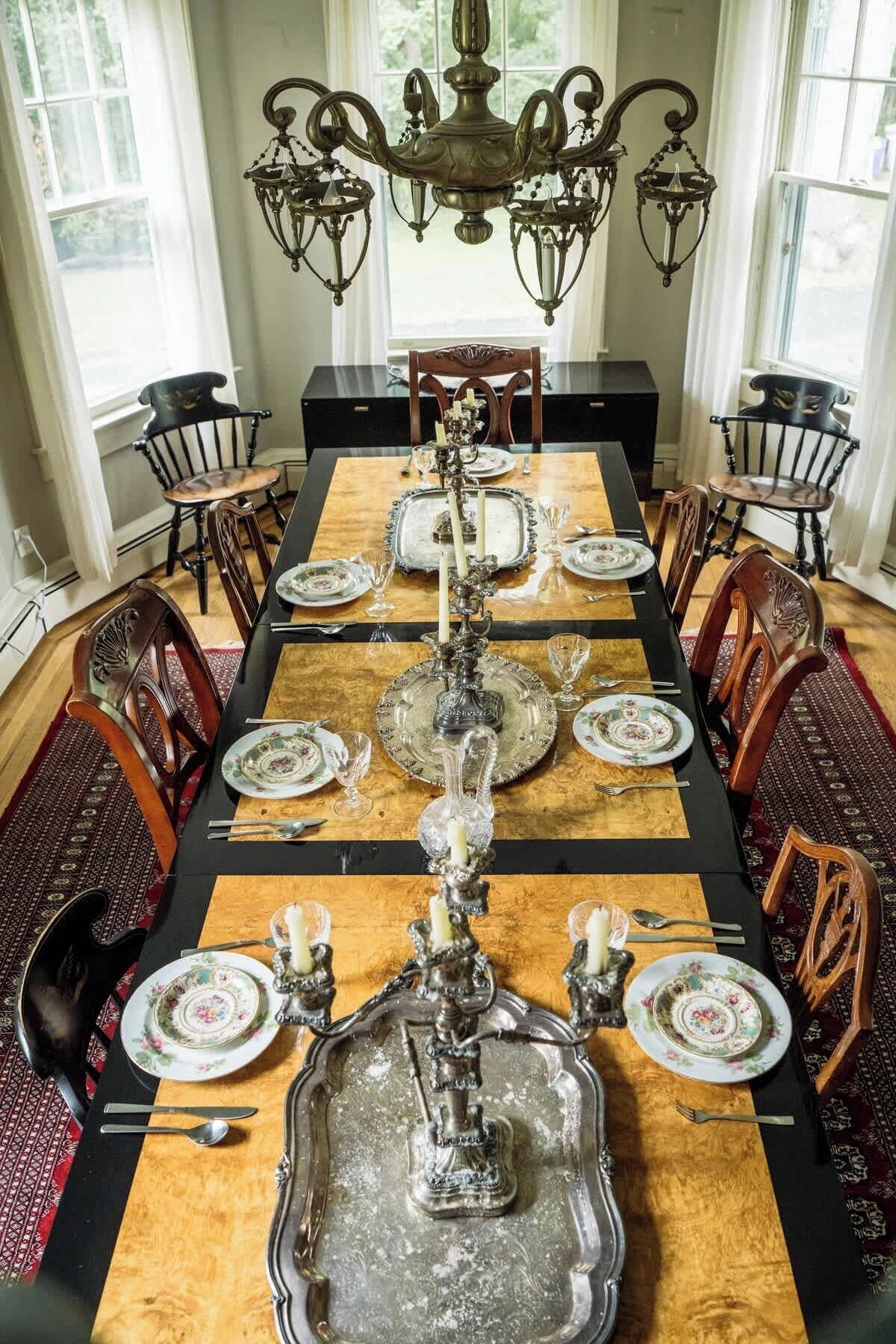 Comedor con una mesa larga dispuesta para seis personas, rodeada de sillas.