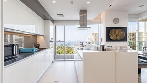 Cocina moderna con una isla grande, vista al mar y un comedor con vistas.