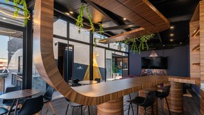 Een moderne barruimte met houten meubels en hangende planten.