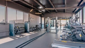 Een sportschool met loopbanden, krachttoestellen en losse gewichten.