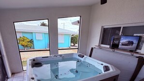A spa area with a hot tub, a ceiling fan, and a television on a stand. - Casa Del Mar Waterfront Home On Dawon Canal!
Boat Lift and Hot Tub (Saint James City)