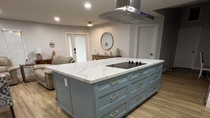 A modern kitchen with a large island, wooden flooring, and a built-in stove. - Casa Del Mar Waterfront Home On Dawon Canal!
Boat Lift and Hot Tub (Saint James City)