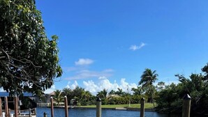 A dock with chairs and a grassy area beside a body of water. - Casa Del Mar Waterfront Home On Dawon Canal!
Boat Lift and Hot Tub (Saint James City)