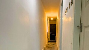 A hallway with marble flooring, white walls, and a door at the end. - Modern 2 Bed Flat - Ideal for Families  (Ashton-under-Lyne)