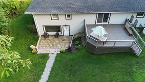 A two-story house with a patio, a deck, and a small garden. - Luxury|Pool Table|Movie Room|Poker|Nature Oasis (Chagrin Falls)