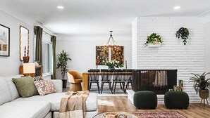 Un salon moderne avec un canapé, une table à manger et une cheminée.
