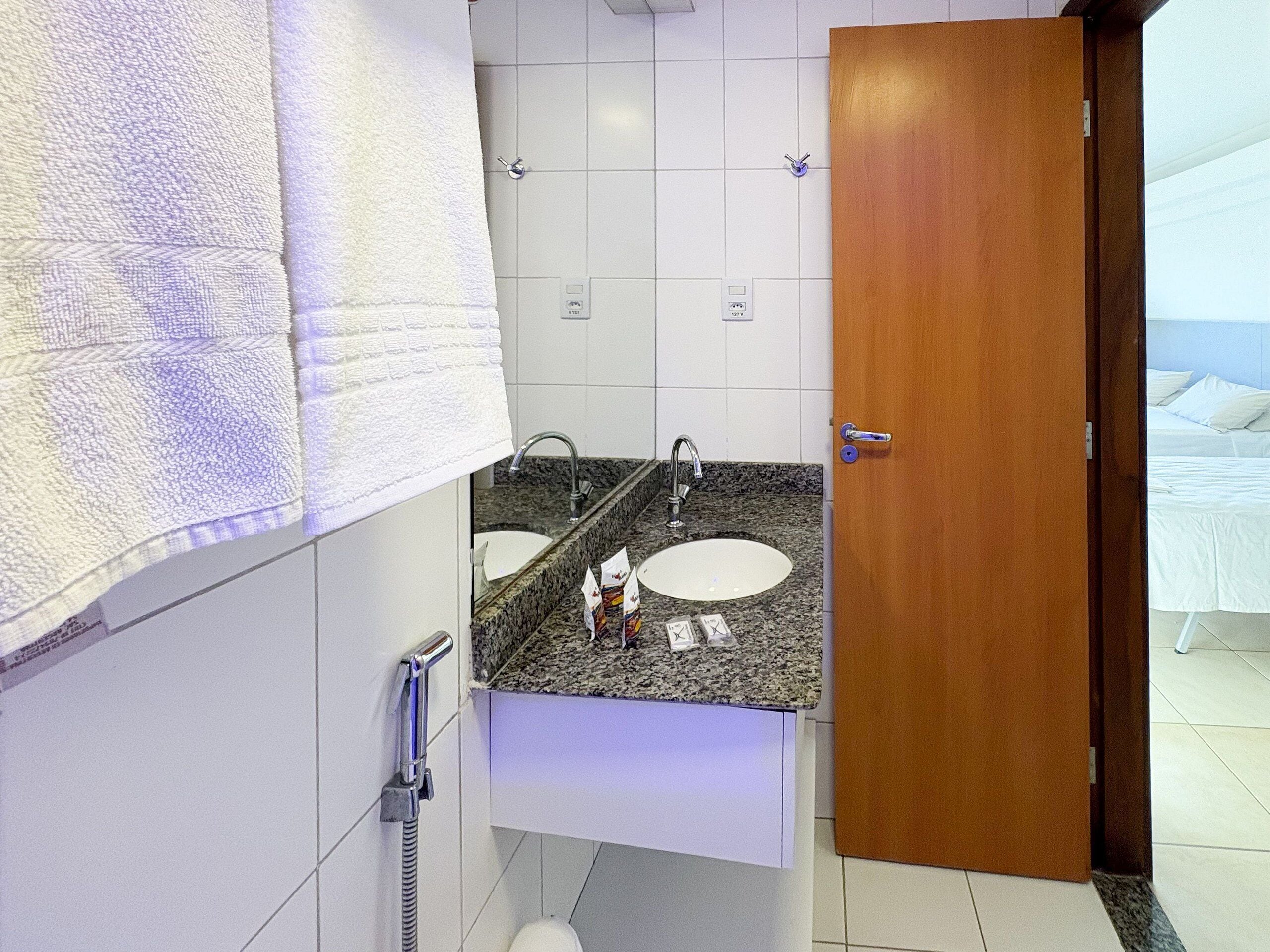 Casa de banho com duas pias, chuveiro e sanita.