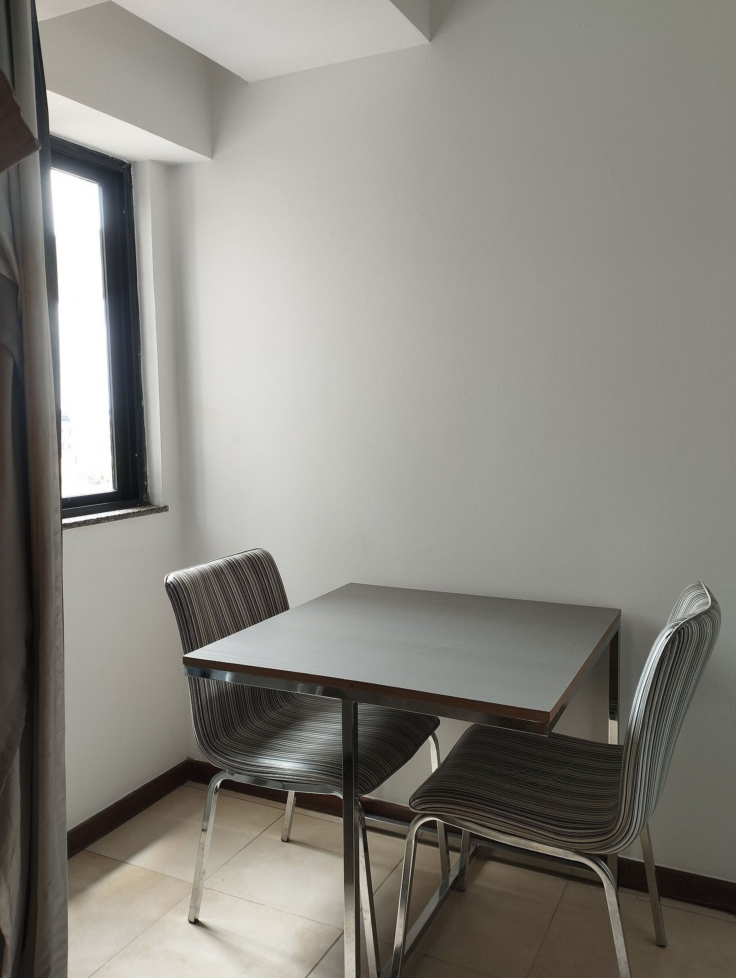 A dining area with a rectangular table and four chairs.