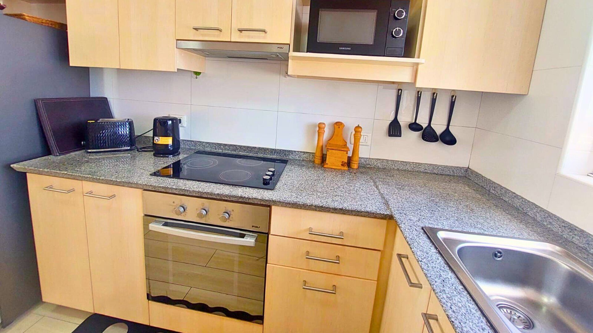 A kitchen with a built-in microwave, stove, oven, and sink.