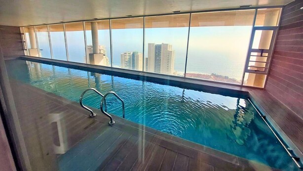 Une piscine intérieure offrant une vue sur les gratte-ciel.