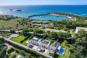 Villa La Soleil with a pool, surrounded by lush greenery and a view of the sea.
