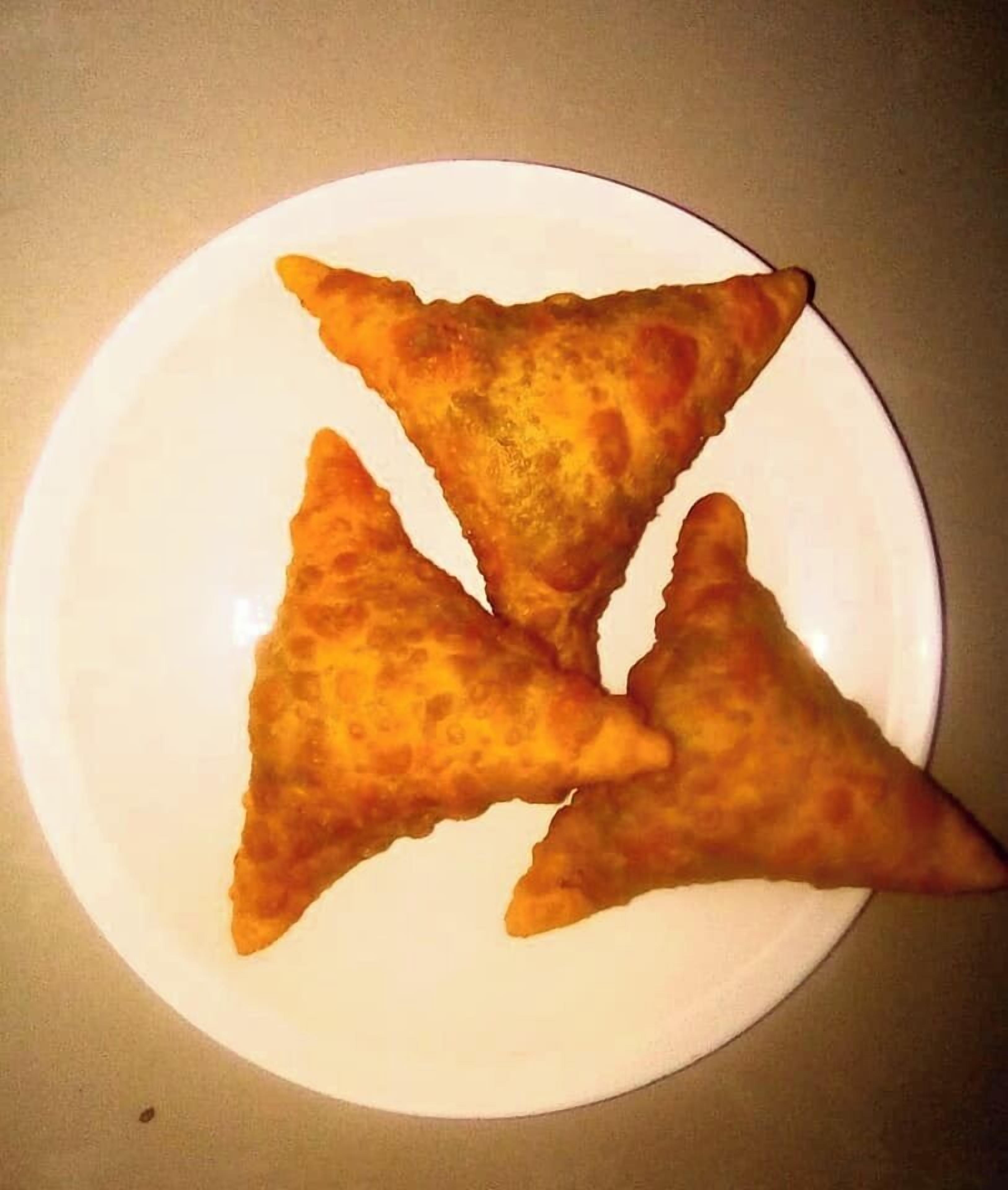 Un plato con tres pasteles triangulares.