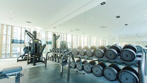 A gym with weightlifting equipment, including dumbbells and a bench. - Modern Executive Studio Apartment at Lennox (Accra)