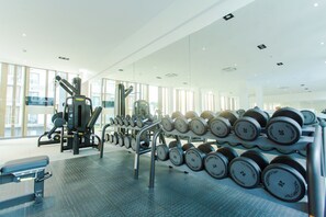 A gym with weightlifting equipment, including dumbbells and a bench. - Modern Executive Studio Apartment at Lennox (Accra)