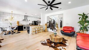 A modern living room with a red sofa, a wooden coffee table, and a ceiling fan.