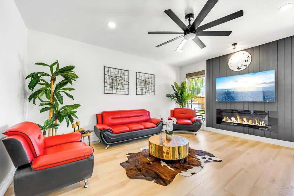 A modern living room with a red sofa, a round coffee table, and a fireplace.