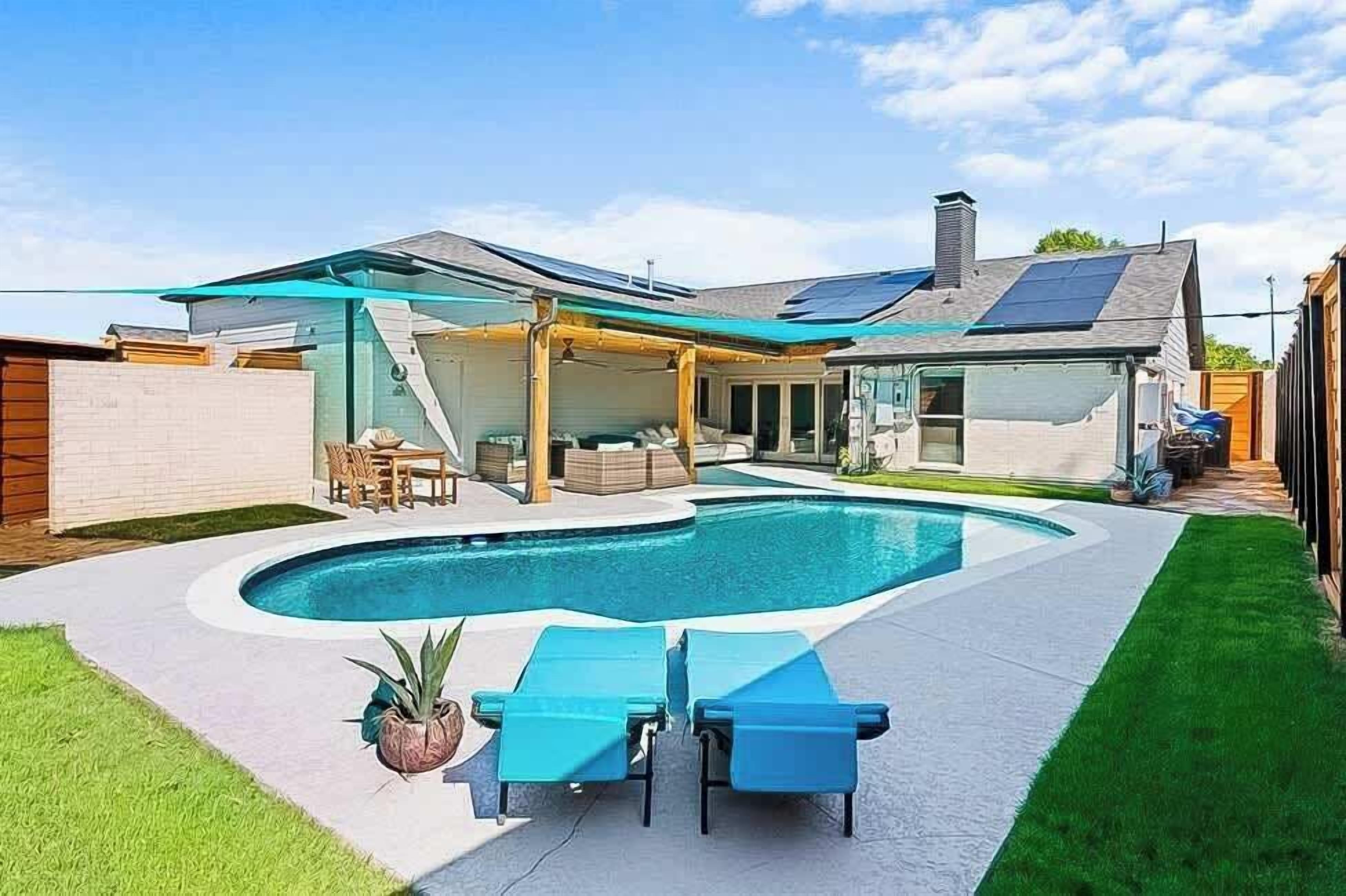 Una casa moderna con piscina, terraza techada y paneles solares.