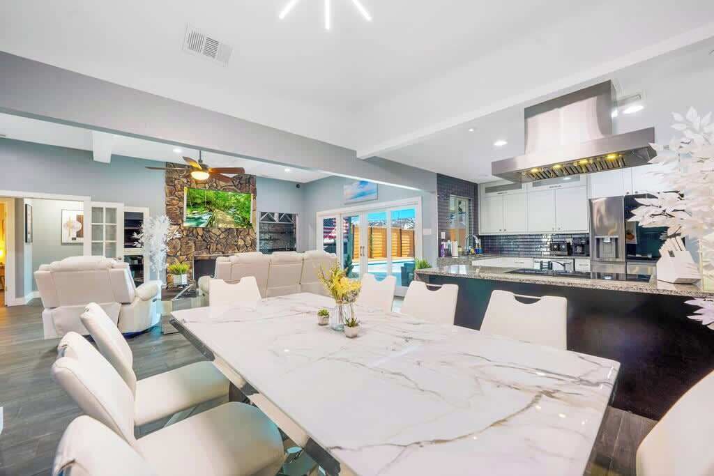 A modern kitchen with a central island, white cabinetry, and a built-in stove.