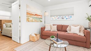 A modern living room with a sofa, a glass coffee table, and a painting on the wall. - The Hydeaway at Hyde Park (Boise)
