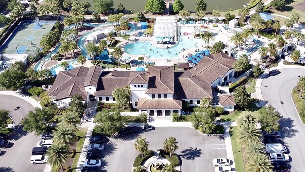 An aerial view of a resort with a central pool, tennis courts, and a parking area. - Last Minute Disney Getaway! Villa with Private Pool & Hot Tub. Book Now! #18234 (Orlando)