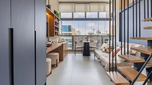 Eine moderne Wohnung mit Balkon, Essbereich und Treppe.