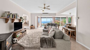 Ein geräumiges Wohnzimmer mit Kamin, Fernseher und einer Couch.
