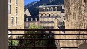 Un balcone con vista su una montagna e degli edifici.