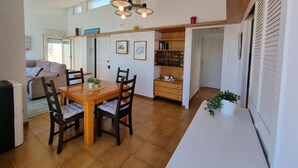 Un comedor con una mesa y sillas de madera, un aplique de techo y vistas a un balcón.