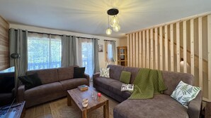 A cozy living room with two sofas, a coffee table, and a wooden staircase. - New chalet in Vars, 10 guests, 300m from slopes (Vars)