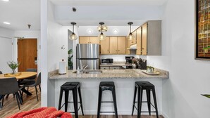 A modern kitchen with a central island, stainless steel appliances, and pendant lighting. - Walk to PCMR • Chic Top-Floor Mountain Condo (Park City)