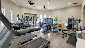 Un gimnasio con cintas de correr, máquinas de pesas y pelotas de ejercicio.