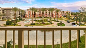 Zona residencial con varios edificios de apartamentos, un área central ajardinada con palmeras y una entrada circular.