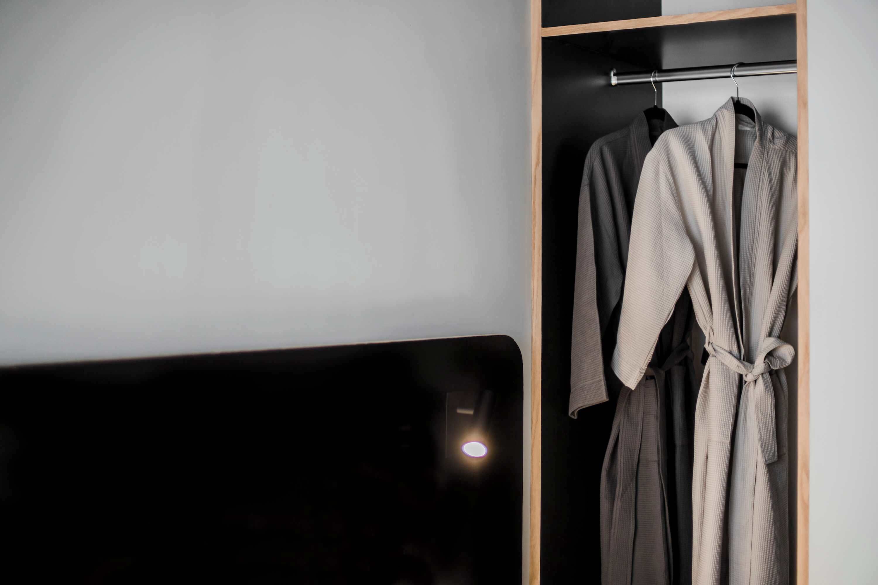 A wardrobe with a hanging rod and a mirror.