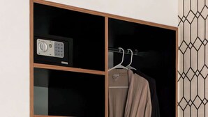 A wardrobe with a digital lock, a hanging rack with clothes, a coffee maker, and a plate with snacks. - Puerta roja Increible ubicacion en condesa suite (Ciudad de México)