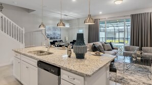 A modern kitchen with granite countertops, stainless steel appliances, and pendant lighting. - Last Minute Disney Getaway! Private Pool & Themed Bedrooms. Book Now! #150903 (Orlando)