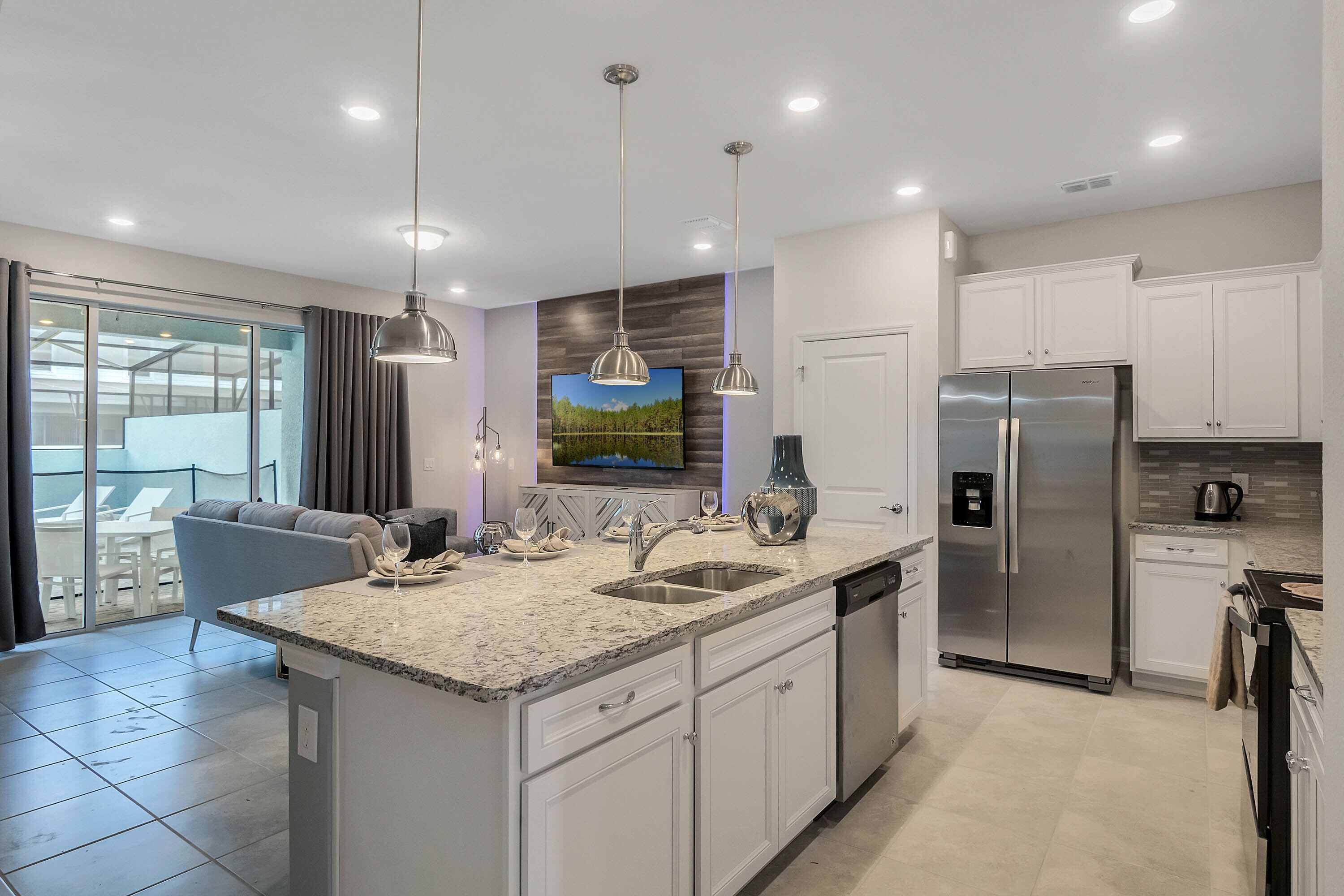 A modern kitchen with a central island, stainless steel appliances, and pendant lighting.