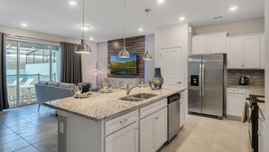 A modern kitchen with a central island, stainless steel appliances, and pendant lighting. - Last Minute Disney Getaway! Private Pool & Themed Bedrooms. Book Now! #150903 (Orlando)
