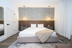 A modern bedroom with a large bed, two bedside tables, and a wall-mounted light fixture. - Disney! Luxury Townhouse with Private Pool & Themed Bedrooms. Book Now! #DP60 (Orlando)