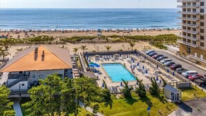 Un hôtel doté d'une piscine, offrant une vue sur la plage et disposant d'un parking.