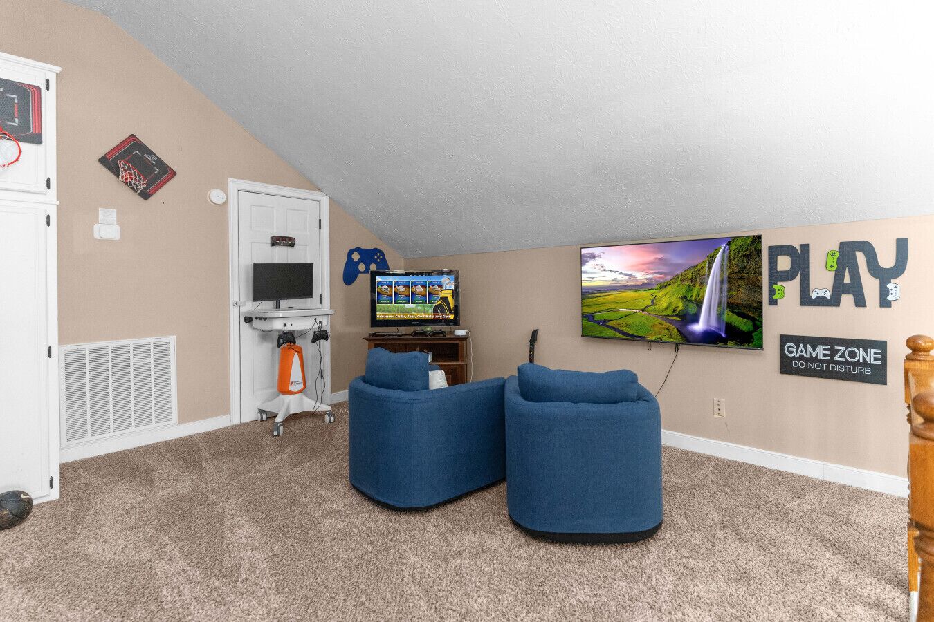 Een kamer met een televisie, game-opstelling en een bordje 'GAME ZONE'.