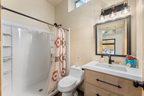 A bathroom with a shower, toilet, sink, and vanity. - Stargazer’s Sanctuary • Observatory Dome Retreat: Sauna & Hot Tub (Sedona)