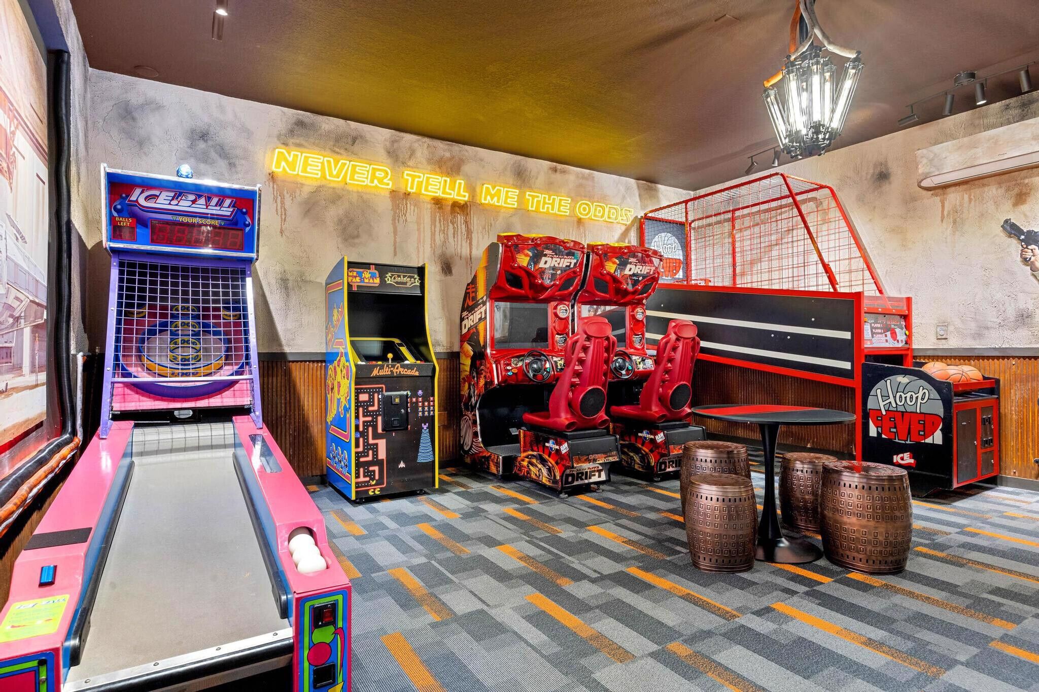 Une salle d’arcade proposant divers jeux, notamment un panier de basket et un jeu de course.