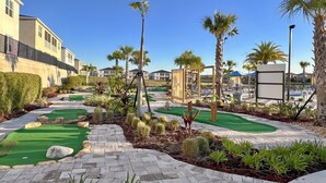 A golf course with a brick pathway, palm trees, and a clear blue sky. - Disney Getaway! Luxury Townhouse with Private Pool. Book Now! #CG902 (Orlando)