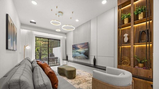 Una sala moderna con un sofá gris, un sillón de mimbre y un cuadro en la pared.