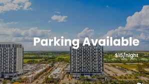 A view of a hotel complex with multiple high-rise buildings, a parking area, and a clear sky. - DTW Doral 2 BD Condo and Skyline Views (Miami)