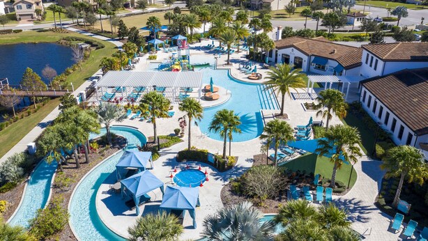 Vista aerea di un resort con una grande piscina, palme e diverse zone relax.