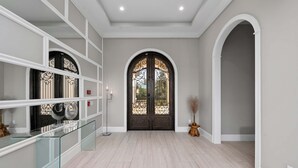 A spacious hallway with a large, ornate double door, a glass railing, and a polished wooden floor. - Last Minute Disney Getaway! Private Pool & Home Theater. Book Now! #158253 (Orlando)