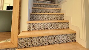 A staircase with floral-patterned steps and wooden handrails. - L'écrin du Sancy, a gentle cocoon just a stone's throw from La Bourboule town center. (La Bourboule)