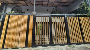 A gated entrance with vertical wooden slats and a metal gate. - Pepe's House Usaquén Bogotá -Small Hotel (Bogotá)