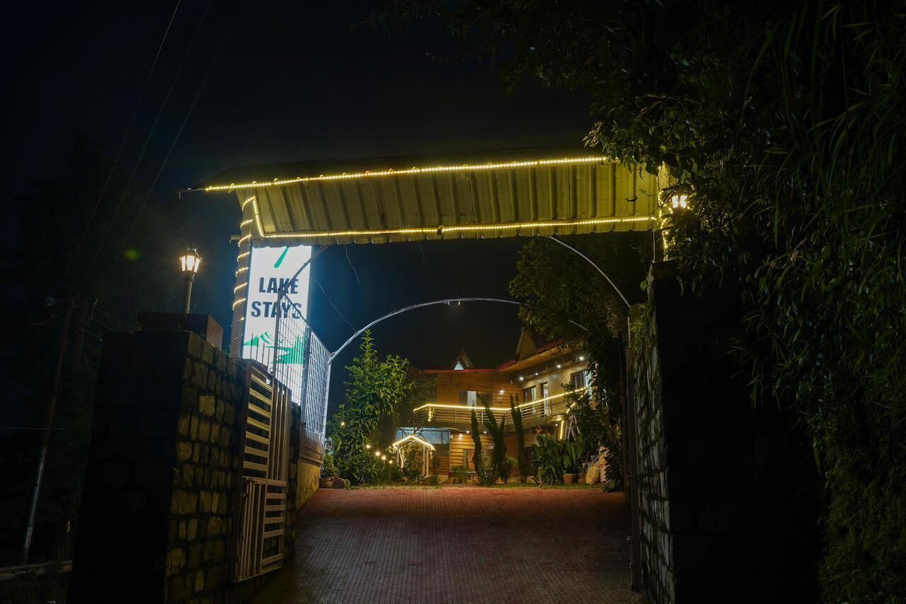 A hotel entrance at night with a sign reading "LAKE STAYS".